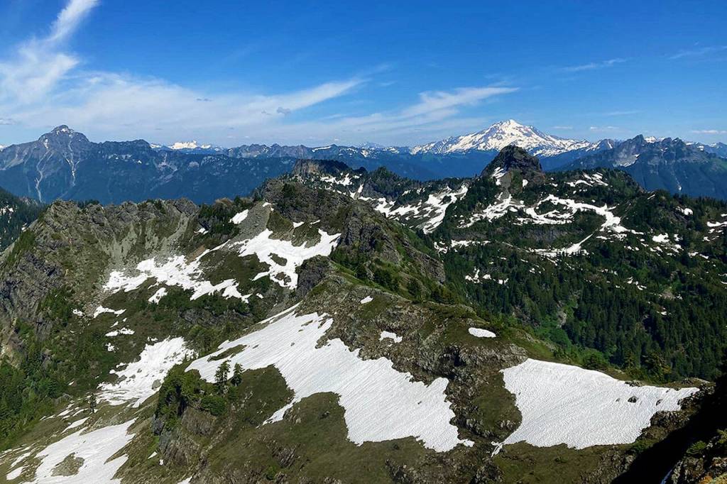 Snow-capped Glacier Peak is visible in the east-facing vista from the summit of Mount Dickerman, 5,760 feet in the sky, on July 24. (Ellen Dennis / The Herald)