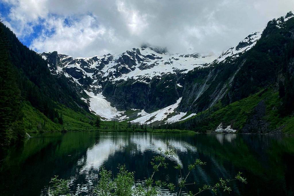Cadet Peak is reflected in the glassy water of Goat Lake on July 4. (Ellen Dennis / The Herald)