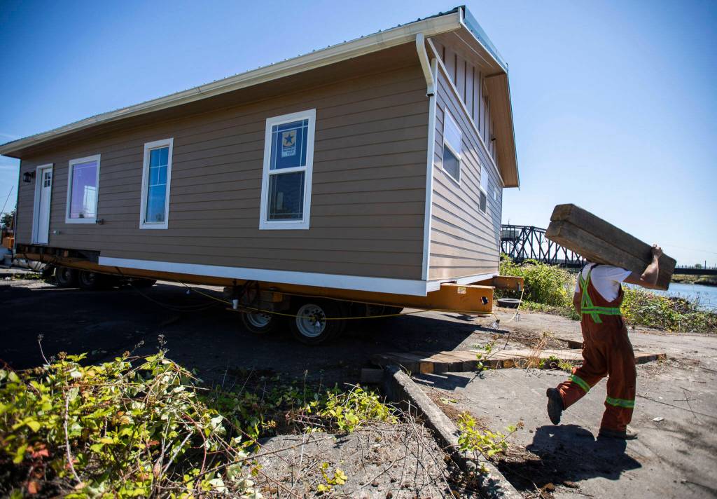 Nickel Bros workers prep the barge for the home to be loaded on Thursday, July 21, 2022 in Marysville, Washington. (Olivia Vanni / The Herald)