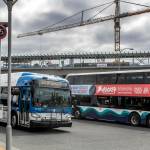 Buses cross routes at the Lynnwood Transit Center in the shadow of light rail station construction Friday afternoon. (Kevin Clark / The Herald)