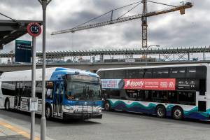 Buses cross routes at the Lynnwood Transit Center in the shadow of the lightrail station construction Friday afternoon in Lynnwood, Washington on July 22, 2022. (Kevin Clark / The Herald)