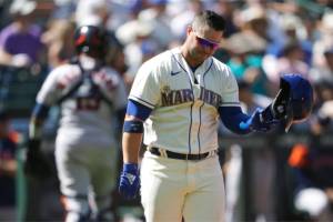 Seattle Mariners' Ty France holds his helmet after striking out swinging with a man on base to end the seventh inning of a baseball game against the Houston Astros, Sunday, July 24, 2022, in Seattle. (AP Photo/Ted S. Warren)