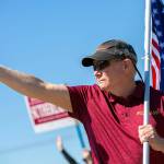 State Representative Robert Sutherland, who is seeking re-election in the 39th District this year, gives a thumbs-up to passing drivers as he and a few volunteers wave flags and campaign signs along the side of State Route 9 on Friday, July 22, 2022, in Lake Stevens, Washington. (Ryan Berry / The Herald)
