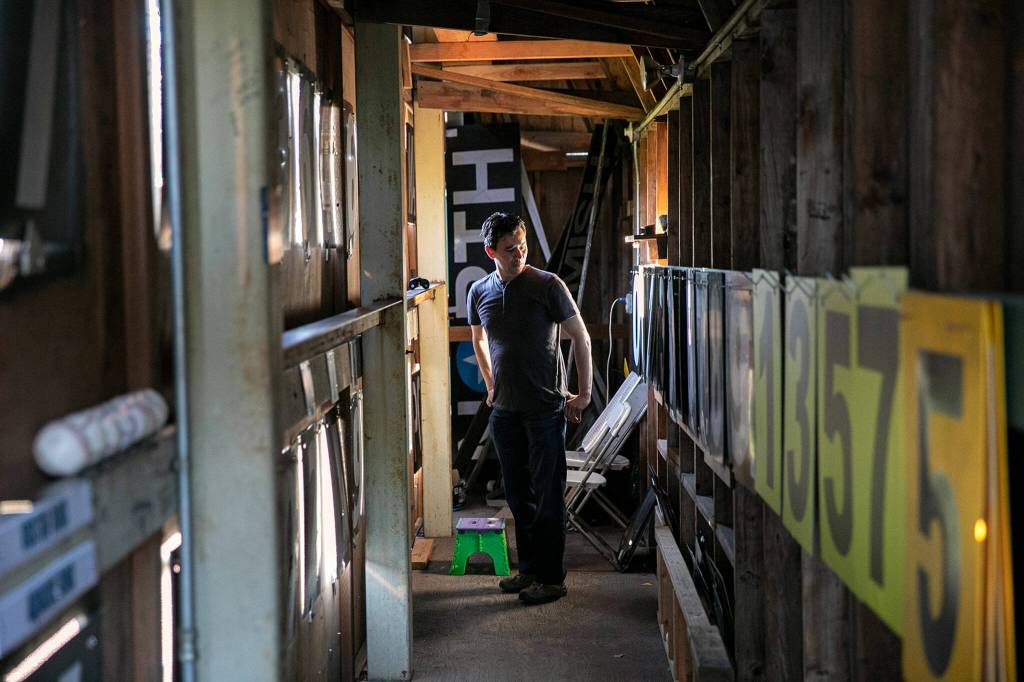 Nick Patterson has a moment of panic as he is left unaccompanied to run the scoreboard as the Aquasox begin playing against Eugene on Saturday, July 23, 2022, at Funko Field in Everett, Washington. (Ryan Berry / The Herald)