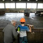 Joel Christensen, who was born with Infantile Refsum disease, causing him to be unable to see or fully hear, stands with his grandfather Harold at his side as he tosses trash into the pit at the Airport Road Recycling & Transfer Station in Everett. Going to the transfer station is one of Joels favorite activities with the vibration of humming machinery, the whooshing of front-end loaders and the tactile nature of his familys trash all stimulating his strongest senses. (Ryan Berry / The Herald)