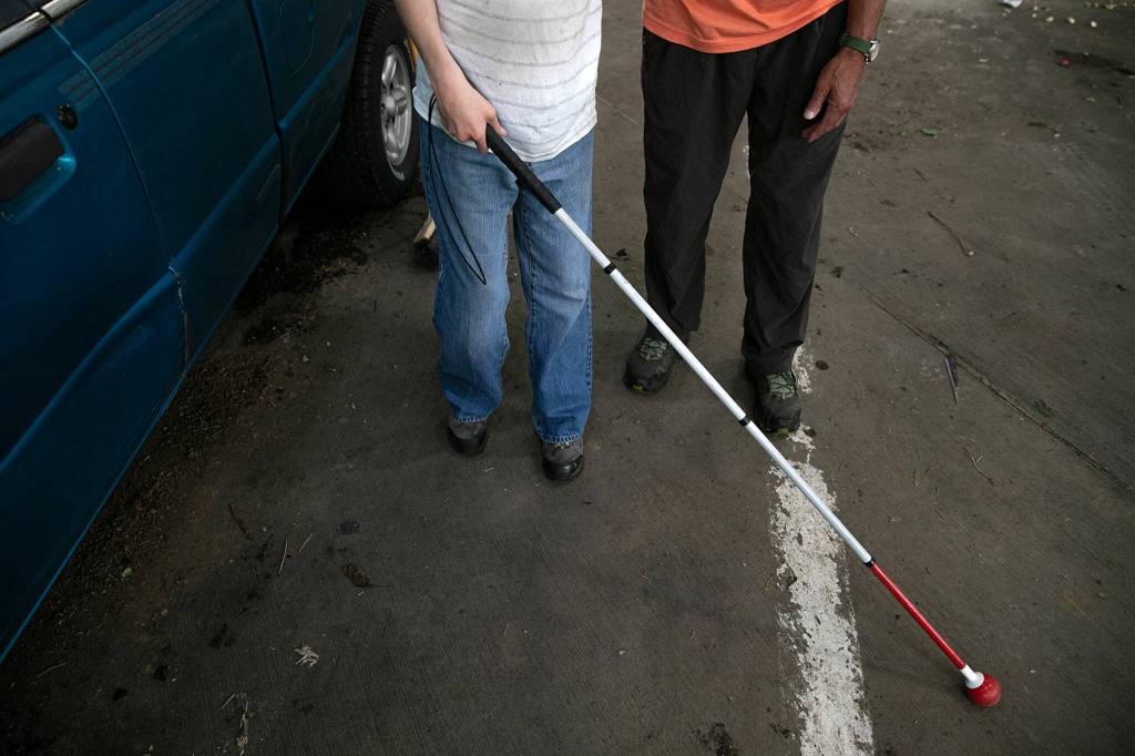 Joel Christensen, left, stands with his father Craig before getting into the car to head out after helping dump his familys trash at the Airport Road Recycling & Transfer Station in Everett. Craig Christensen said the family was probably off to Costco, another favorite activity of Joels. (Ryan Berry / The Herald)