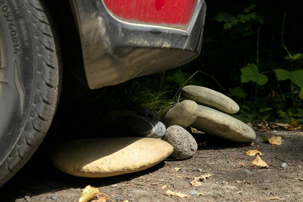 Stones begin to pile up beside a car as a group of rockhounds collect specimens to bring home on July 23,along the Nooksack River near Deming. (Ryan Berry / The Herald)