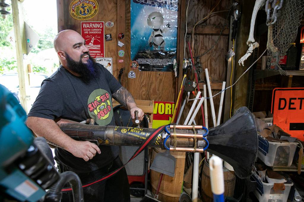 Josh Haazard points his gramophonezooka while walking around his workshop. (Ryan Berry / The Herald)
