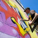 Jason Clifton, who hails from Ellensburg, works on a mural in a downtown alley near Vintage Cafe on Friday, in Everett. Clifton said he always wanted to be a comic book artist growing up, and is now taking one of his favorite 90s comics  The Maxx  and transposing some of its imagery onto a wall between a garage door and a pad-mounted transformer. (Ryan Berry / The Herald)