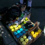 Faust, an artist from Arizona, grabs a new can of spray paint while working on a mural with some fellow artists Friday, in downtown Everett. (Ryan Berry / The Herald)