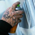 Faust lightly adds tone to the beginnings of a piece he and fellow artists are creating for Going All City NW on Friday, in downtown Everett. (Ryan Berry / The Herald)