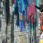 Everett artist Shisha, above, and Karoe of Tyler, Texas, work on a full-building mural together on Friday, in downtown Everett. (Ryan Berry / The Herald)