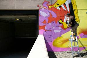 Jason Clifton, of Ellensburg, works on a mural on Friday, Aug. 5, 2022, in downtown Everett, Washington. (Ryan Berry / The Herald)