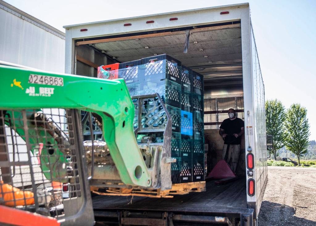 Crates of milk are loaded into a truck at Farmer Frog on Wednesday, in Snohomish. (Olivia Vanni / The Herald)