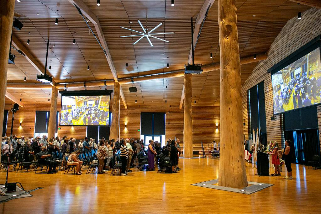 Mourners rise to their feet in song Saturday during a memorial service for Terry Williams at the Tulalip Gathering Hall in Tulalip. (Ryan Berry / The Herald)