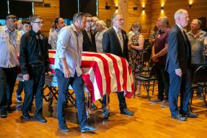 Pallbearers guide elder Terry Williams’ flag-draped casket outside at the conclusion of a memorial service for Williams on Saturday, July 30, 2022, at the Tulalip Gathering Hall in Tulalip, Washington. (Ryan Berry / The Herald)