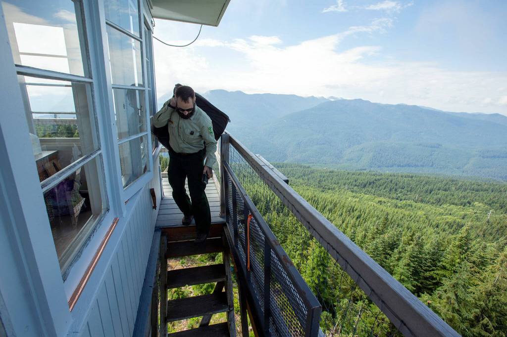 Sam Olsen, fire prevention technician with the Mount Baker-Snoqualmie National Forest, heads down from the top of the North Mountain Fire Lookout on Wednesday, Aug. 10, north of Darrington. (Ryan Berry / The Herald)