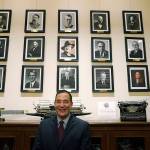 Steve Hobbs, who was sworn in as Washington Secretary of State, Nov. 22, 2021, at the Capitol in Olympia, poses in front of photos of the 15 people who previously held his office. (AP Photo / Ted S. Warren)