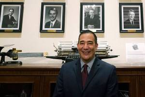 Steve Hobbs, who was sworn in as Washington Secretary of State, Monday, Nov. 22, 2021, at the Capitol in Olympia, Wash., poses in front of photos of the 15 people who previously held his office. Hobbs, a former state senator from Lake Stevens, Wash., is the first person of color to head the office and the first Democrat to serve as Secretary in more than 50 years. He replaces Republican Secretary of State Kim Wyman, who resigned to accept an election security job in the Biden administration. (AP Photo/Ted S. Warren)