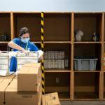 Carri Tokareff, an Everett Food Bank employee since late last year, packs bags while surrounded by empty shelves Friday, at the Everett Food Bank on Broadway in Everett. Tokareff said the food bank has never seen a shortage of food like this one, and that its due to an economic climate in which more people are using the food banks services and fewer people are able to donate. The food bank has had to reduce its services from once a week per family to twice a month, and the boxes of supplies they do offer are now less diverse and missing things like sanitary products. (Ryan Berry / The Herald)