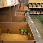 A dry goods packing station is nearly devoid of food as donations plummet on Friday, Aug. 5, 2022, at the Everett Food Bank on Broadway in Everett, Washington. (Ryan Berry / The Herald)