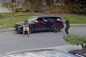 A frame from video taken by a nearby security camera shows a Bothell police officer (right) shooting a man who allegedly charged him with a knife. (Snohomish County Multiple Agency Response Team) 20210128