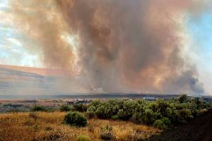 RETRANSMISSION TO CORRECT STATE - This photo provided by the Washington State Department of Transportation shows smoke from a wildfire burning south of Lind, Wash. on Thursday, Aug. 4, 2022. Sheriff's officials are telling residents in the town of Lind in eastern Washington to evacuate because of a growing wildfire south of town that was burning homes. (Washington State Department of Transportation via AP)