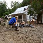 Teresa Reynolds sits exhausted as members of her community clean the debris from their flood ravaged homes at Ogden Hollar in Hindman, Ky., July 30. (Timothy D. Easley / Associated Press)