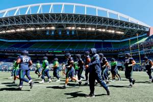 Seattle Seahawks offensive and defensive linemen jog up the field before the team's mock NFL football game Saturday, Aug. 6, 2022, in Seattle. (Jennifer Buchanan/The Seattle Times via AP)