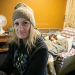 Melinda Parke sits inside a Days Inn motel room as her son, Elijah, sleeps on his chair behind her in April, in Everett. Used recently to house homeless indivudals and families with emergency vouchers, the hotel is proposed for purchase by the county for use as emergency supportive housing. (Ryan Berry / The Herald file photo)
