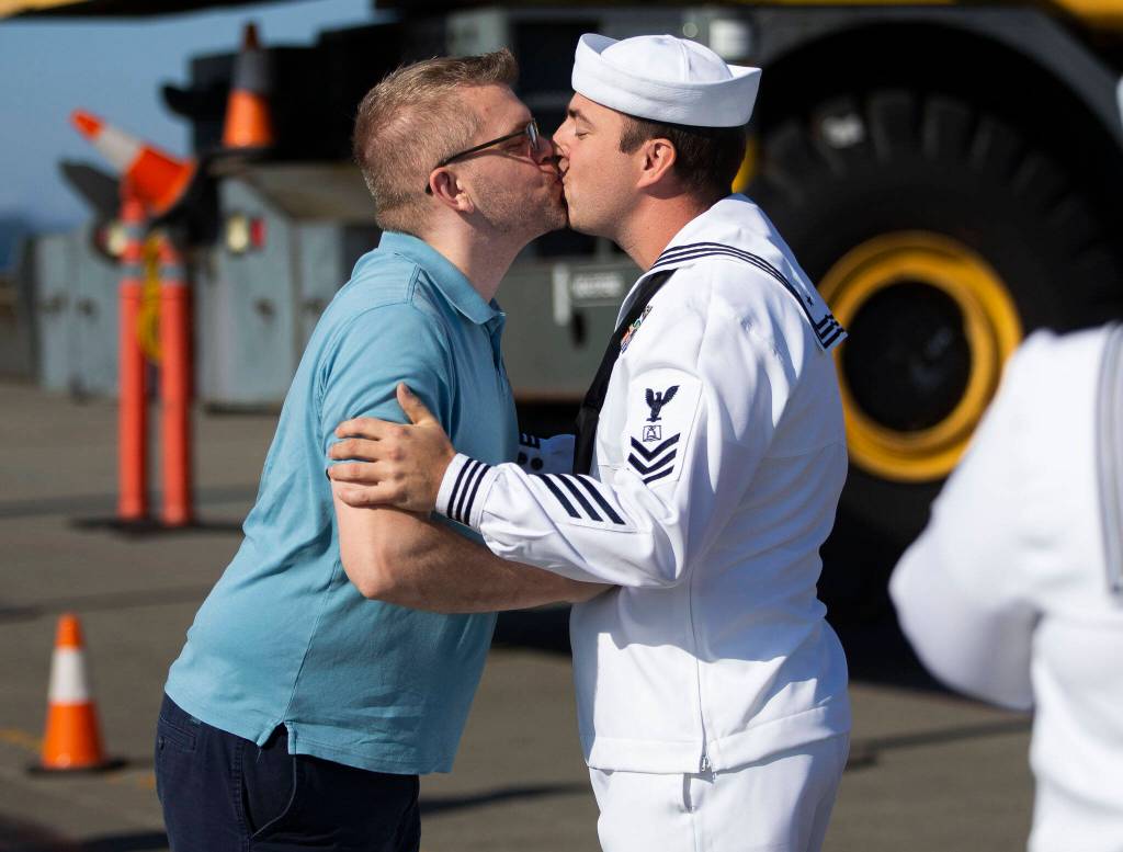 Kevin Crofts, right, kisses Daniel Pawloswki as the first person off of the U.S.S. Gridley at Naval Station Everett on Thursday, in Everett. (Olivia Vanni / The Herald)