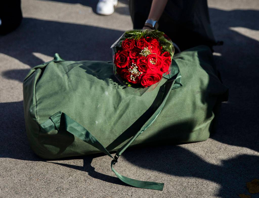 A bouquet of roses lays on top of a duffel bag at Naval Station Everett on Thursday, in Everett. (Olivia Vanni / The Herald)