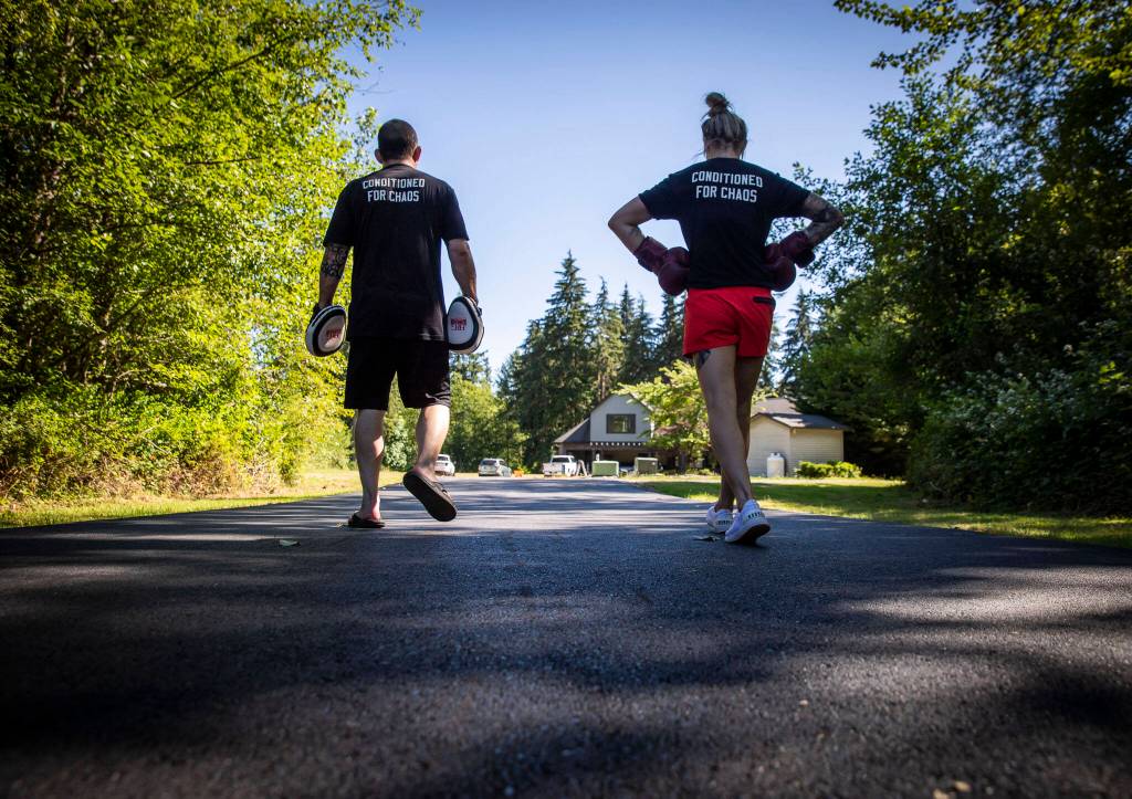 After a training session, Charlie Pearson and Miranda Granger walk down her driveway in silence on Tuesday, July 12, 2022, in Lake Stevens, Washington. (Olivia Vanni / The Herald)