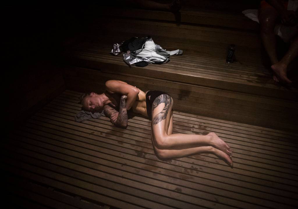 Inside a 180-degree sauna, Miranda Granger lies on her side during her weight cut at the UFC Performance Institute on Aug. 4, 2022, in Las Vegas. Granger spent intervals of 10 minutes, seven minutes and five minutes inside the sauna until she had sweated out enough of her body weight. (Olivia Vanni / The Herald)