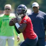 Seahawks quarterback Geno Smith (center) passes as head coach Pete Carroll (left) and assistant quarterbacks coach Kerry Joseph look on during a practice on July 30 in Renton. (AP Photo/Ted S. Warren)
