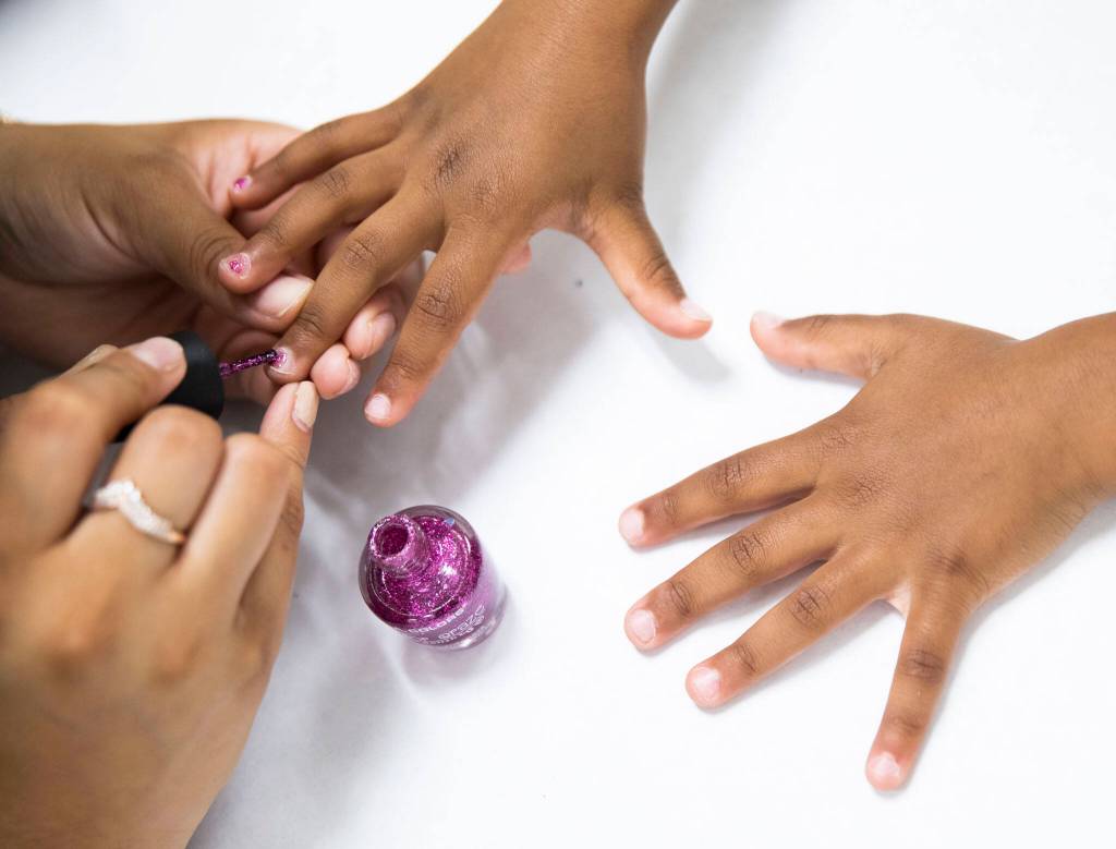 A young girl gets her nails painted with pink sparkle nail polish during Evergreen Beauty Colleges annual back-to-school beauty event on Wednesday, in Everett. (Olivia Vanni / The Herald)