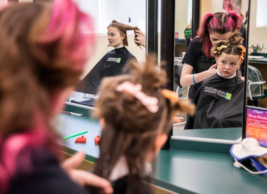 Lucy P., 6, looks around while people get their hair cut during Evergreen Beauty Colleges annual back-to-school beauty event on Wednesday, in Everett. (Olivia Vanni / The Herald)