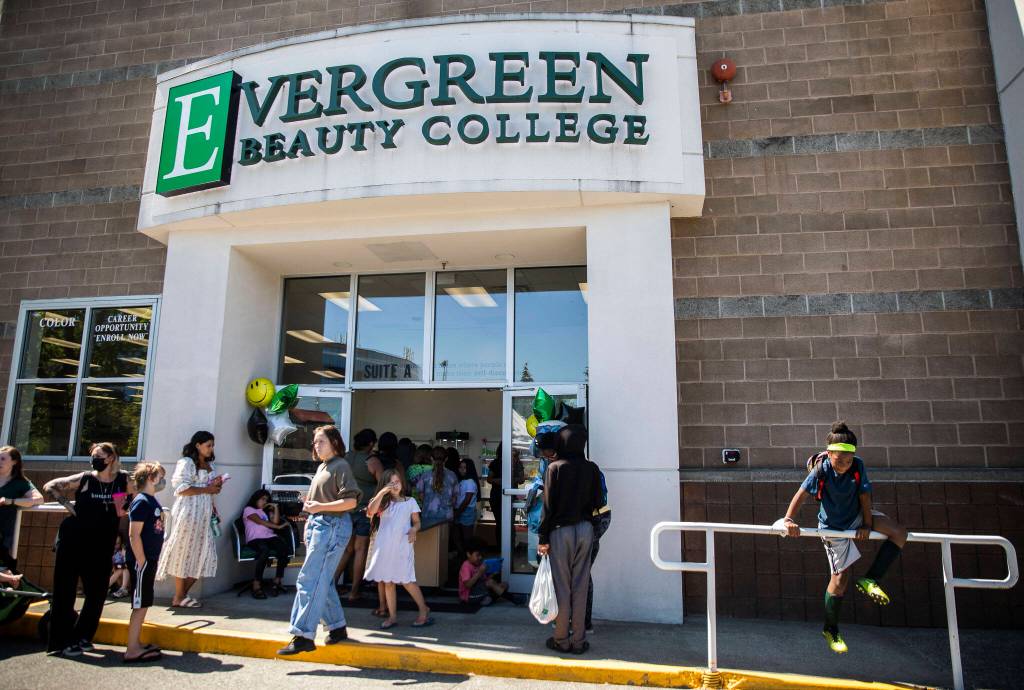 People line up and wait to get inside Evergreen Beauty College for their annual back-to-school beauty event on Wednesday, in Everett. (Olivia Vanni / The Herald)