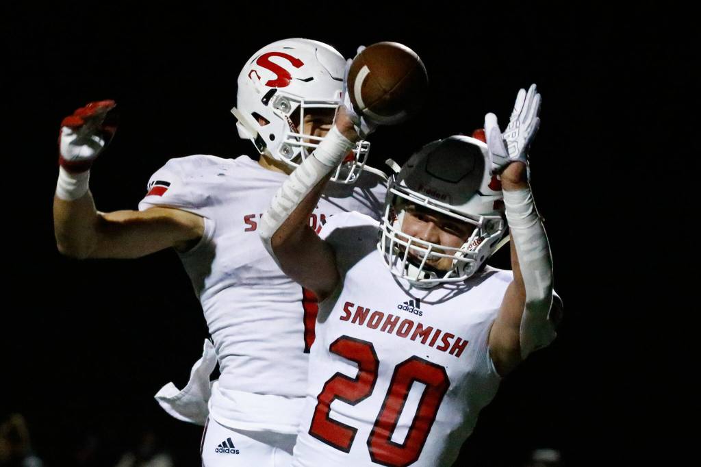 Snohomishs Kyden Gaffney and Snohomishs Mason Orgill (20) celebrate a touchdown against Monroe at Monroe High School on Oct. 22, 2021. (Kevin Clark / The Herald)