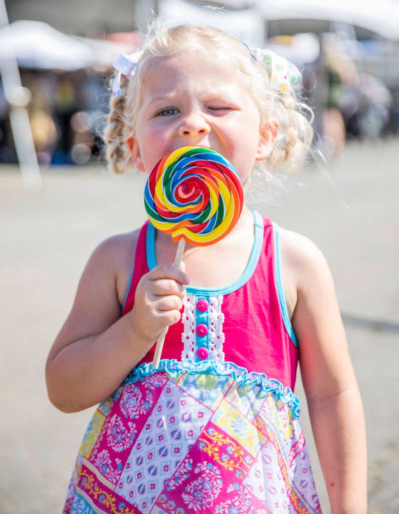 Sarah Huber, 3, enjoys a lollipop during opening day of the Evergreen State Fair on Thursday, in Monroe. (Olivia Vanni / The Herald)