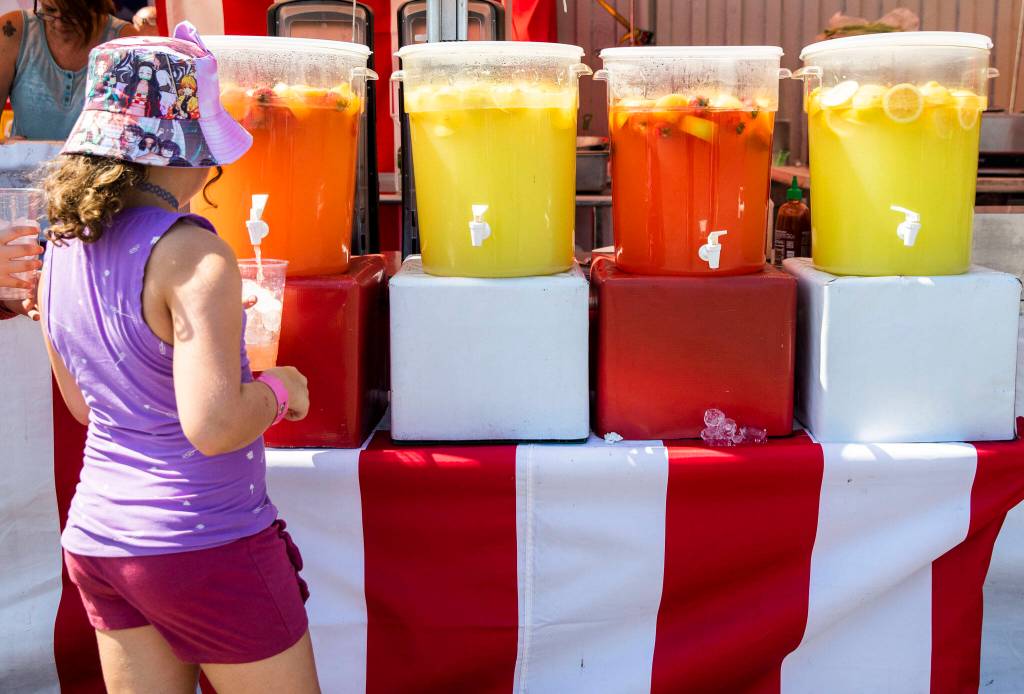 A young girl fills up a cup with strawberry lemonade during opening day of the Evergreen State Fair on Thursday, in Monroe. (Olivia Vanni / The Herald)