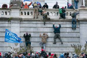 FILE - In this Jan. 6, 2021, file photo, violent insurrectionists loyal to President Donald Trump scale the west wall of the the U.S. Capitol in Washington. Two Seattle police officers who were in Washington, D.C., during the January 6 insurrection were illegally trespassing on Capitol grounds while rioters stormed the building, but lied about their actions, a police watchdog said in a report released Thursday, July 8, 2021. (AP Photo/Jose Luis Magana, File)