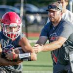 Marysville Pilchucks Kenai Sinaphet (left) takes the hand-off from head coach Dalton Schwetz during the first day of fall practice Wednesday afternoon at Marysville-Pilchuck High School. (Kevin Clark / The Herald)