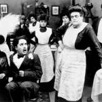 Foreground, from left: Mabel Normand, a pre-Tramp Charlie Chaplin and Marie Dressler star in the 1914 silent comedy, Tillies Punctured Romance. (Wikimedia Commons)