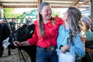 Aleigh Davis, left, becomes emotional and hugs her friend Dylan Carpenter, right, after the sale of her steer Maverick during the Evergreen Youth Livestock Show at the Evergreen State Fair on Saturday, Aug. 27, 2022 in Monroe, Washington. (Olivia Vanni / The Herald)