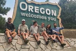 Pacific Crest Trail hikers pose in front of the Oregon Welcomes You sign after crossing into Oregon from California. (The Oregonian)