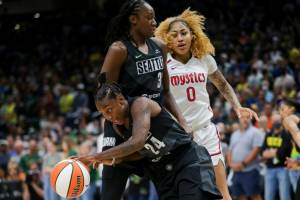 Seattle Storm guard Jewell Loyd (24) gets the rebound and makes a break around Storm center Tina Charles (31) as Washington Mystics center Shakira Austin (0) watches during the first half of Game 1 of a WNBA basketball first-round playoff series Thursday, Aug. 18, 2022, in Seattle. (AP Photo/Lindsey Wasson)