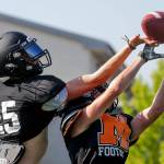 Trent Bublitz, left and Braden Bingham jump for a reception during practice at Monroe High School Tuesday afternoon in Monroe, Washington on August 30, 2022. (Kevin Clark / The Herald)