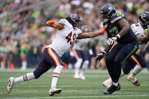 Chicago Bears linebacker Charles Snowden (49) and Seattle Seahawks offensive tackle Charles Cross (67) during an NFL Preseason football game, Thursday, Aug. 18, 2022, in Seattle, WA. The Bears defeated the Seahawks 27-11. (AP Photo/Ben VanHouten)