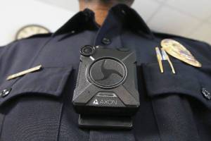 Phoenix Police Department Sgt. Kevin Johnson shows off the new Axon Body 2 body camera after demonstrating to fellow officers how the camera works as another precinct gets their cameras assigned to them Wednesday, July 3, 2019, in Phoenix.  Although body-worn cameras are becoming a police standard nationwide, Phoenix was among the last big departments to adopt their widespread use. (AP Photo/Ross D. Franklin)
